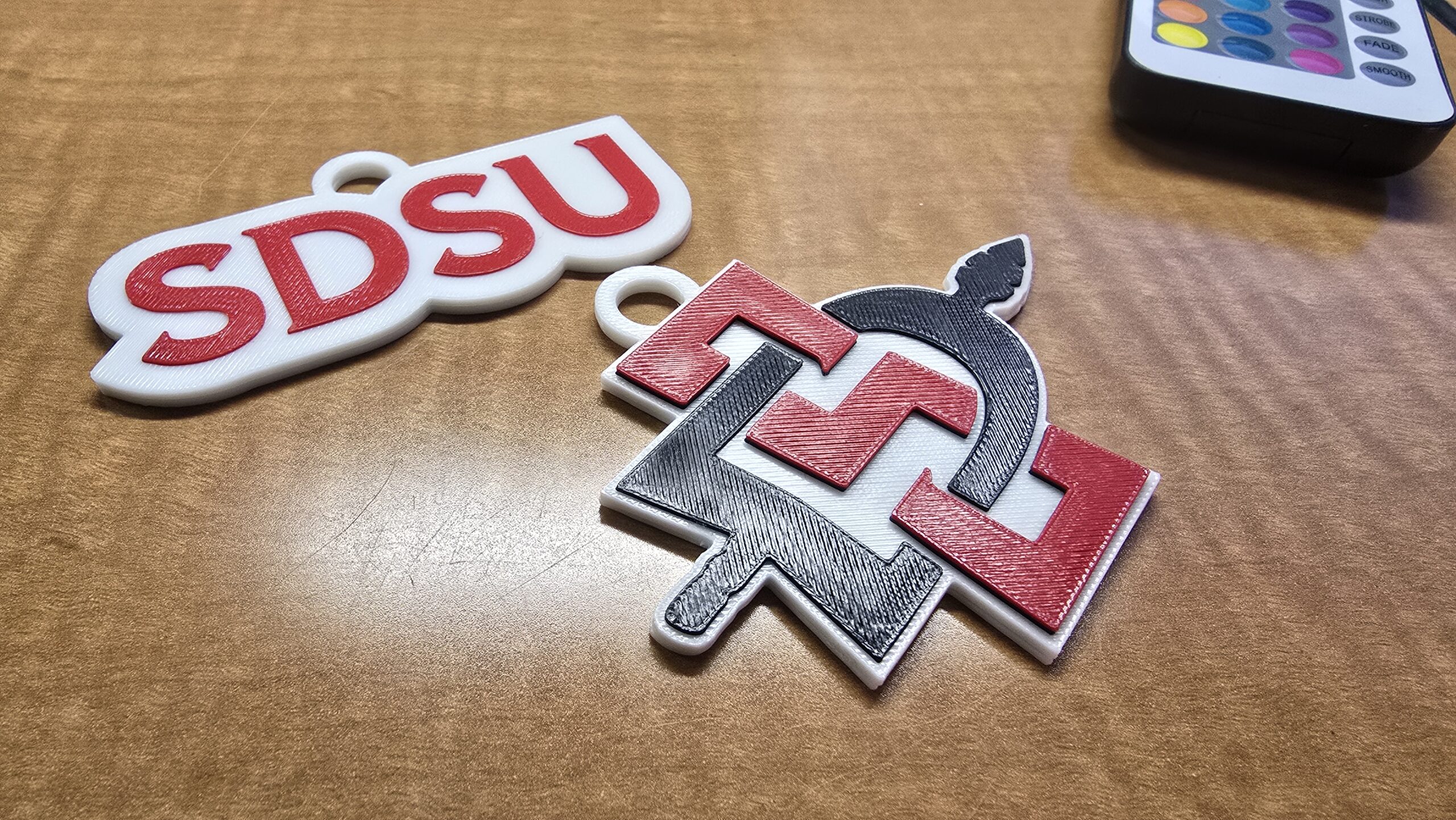 Two SDSU keychains that carry a secret - an embedded NFC card used by outreach reps for interaction tracking.